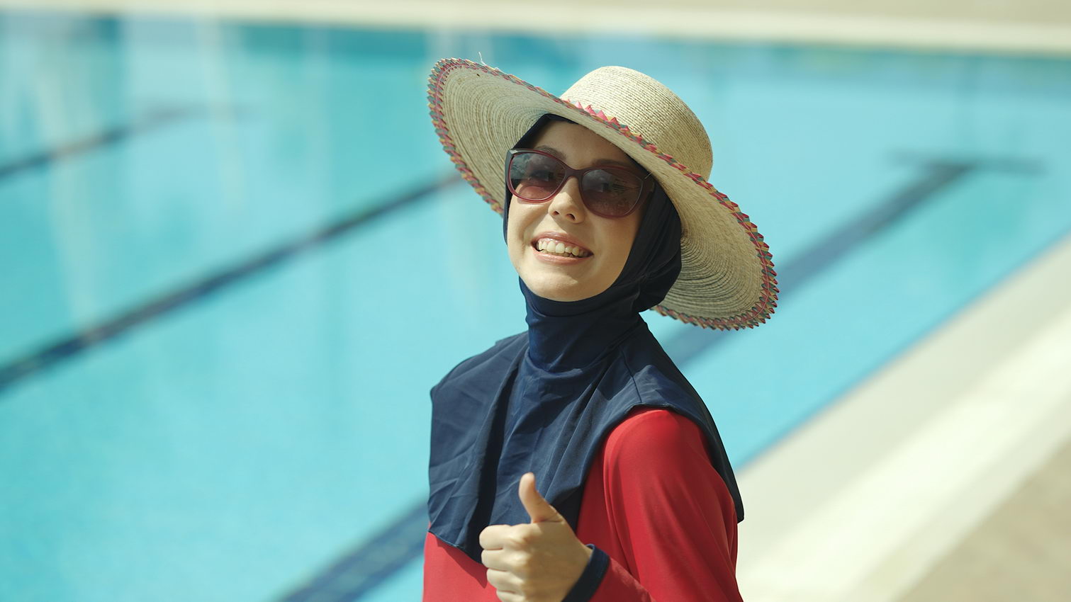 Muslim Woman wearing burkini and hat in a pool